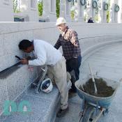 From left to right. Stone Masons, Antonio and John, put the final touches on a drainage system. 