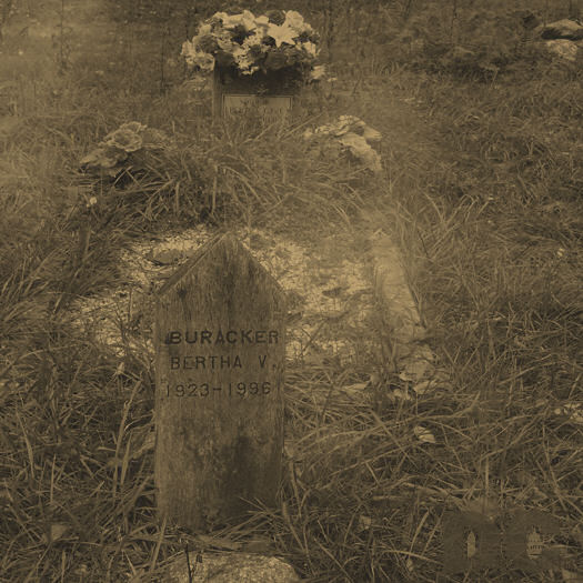 Here is the Gravestone of Bertha V Buracker. The burial mound behind is new.