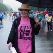 With a big umbrella and a big smile, this survivor walks the race