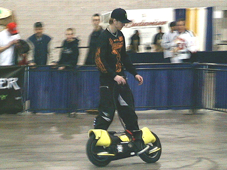 One of the three brothers warming up on a powered foot cruiser before the premiere of The Ball of Steel Stunts Demo.