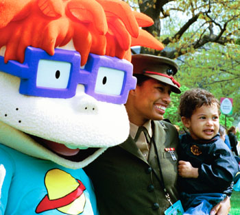 A United States Marine and her son stand for pictures with Chuckie, a character from the cartoon, "Rugrats."