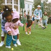 A helping hand is given during the Easter egg roll where little competitors use a spoon to carry a hard-boiled egg through the South Lawn race course and across the finish line