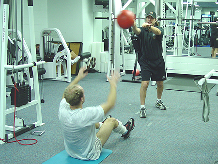 The object of this drill is to throw the ball to the trainer while doing a sit-up.