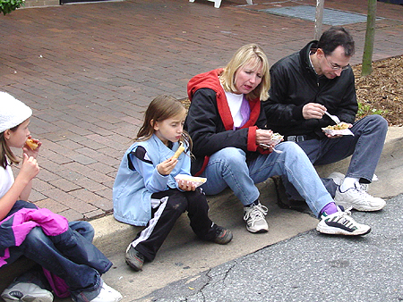 Families take a break from walking around to enjoy their food.