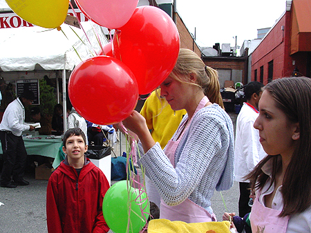 Children wait patiently for a balloon.