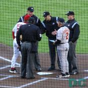 Baltimore Orioles Manager Sam Perlozzo and the Washington Nationals hitting coach meet with the umpires before the start of the game.