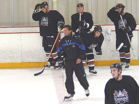 Coach Cassidy skates with his team during their practice.