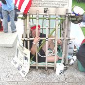 A Vietnam War Vet. demonstrating one type of confinement the Vietnamese soldiers used on our men.