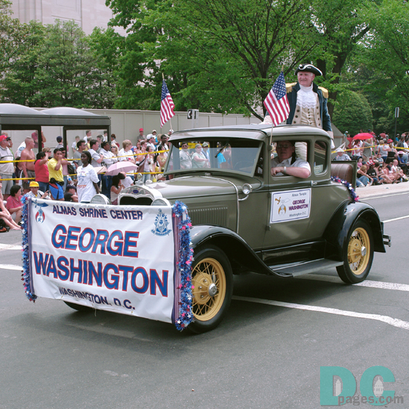 George Wasington standing from vintage rumble seat.