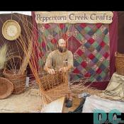 A basketweaver carefully waves the rushes to make final products like the ones behind him.