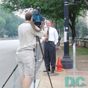 A TV news reporter provides live coverage to his local area news.