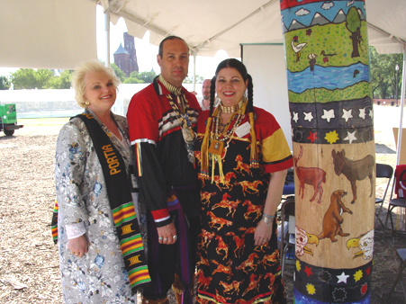 Portia Davidson of the U.S. Army Space and Missile Defense Command Community stands with Professor Marietta Dantonio Fryer and Rik "Winter Bear"Fryer, Art Directors of the Totem Pole in front of their display at the festival