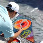 ICAF Young Artist paints his panel for the Art for Peace Pyramid