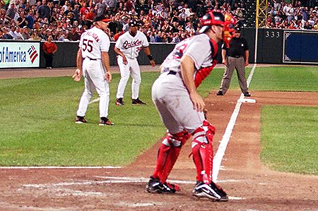 A Boston Red Sox catcher prepares himself to stop the O's from scoring.