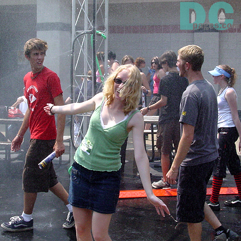A girl enjoys the cooling mist at one of the misting areas erected for the hundreds of concert goers who spent the day in the sweltering heat.