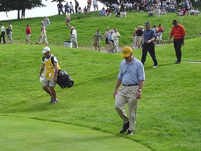 A golfer and his caddy walking to the next hole